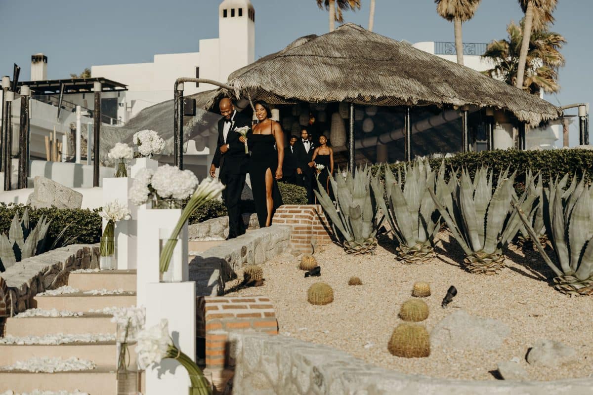 The bridal procession with bridesmaids in Black dresses and groomsmen in Black tuxedos at Monalisa in Cabo San Lucas, Mexico