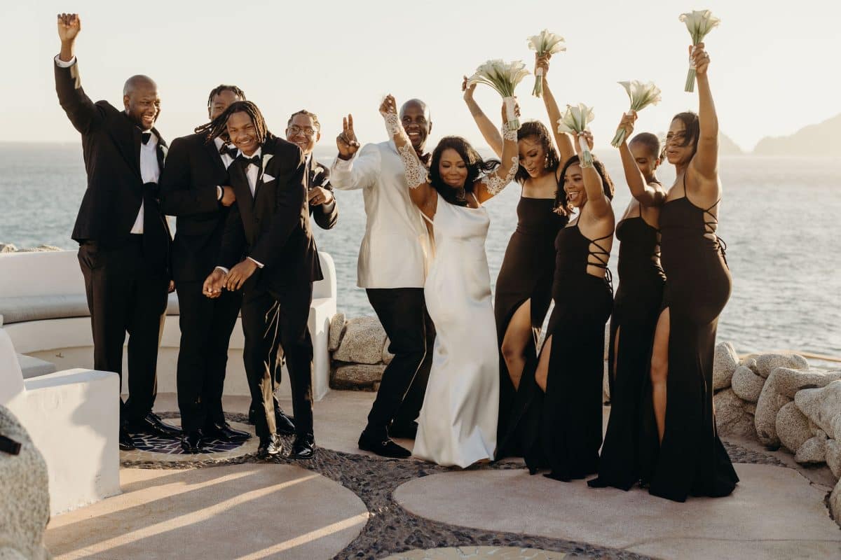 Bridal party groomsmen in Black and bridesmaids in White with bride and groom in White