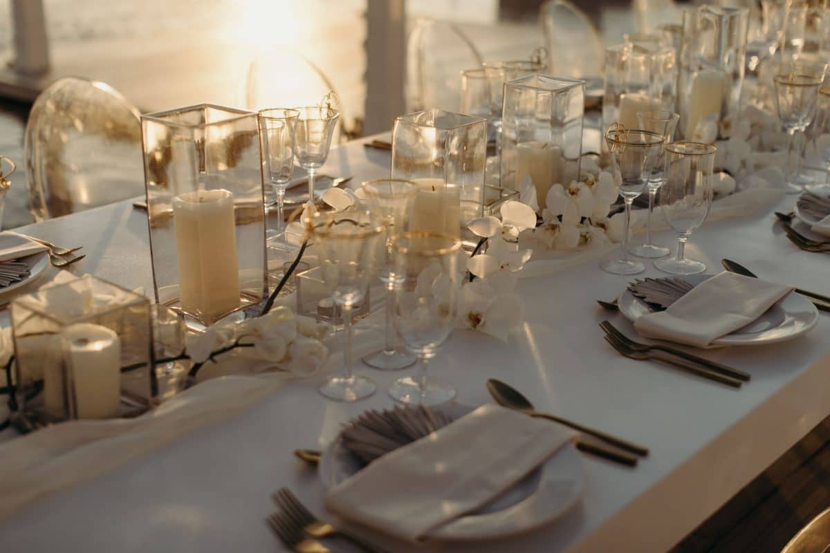 Tabletop wedding decor in white and gold with hurricanes and candles