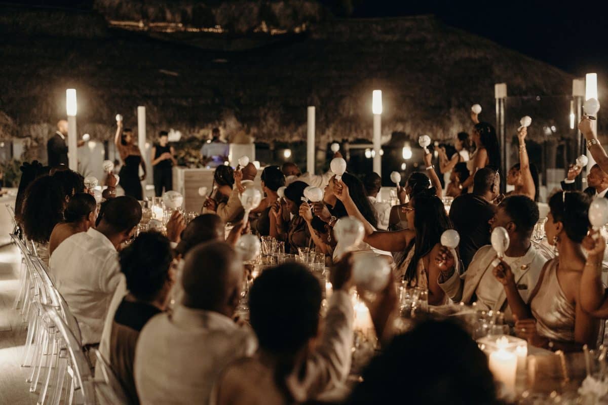 Evening wedding reception in Cabo San Lucas with guests shaking maracas in the air