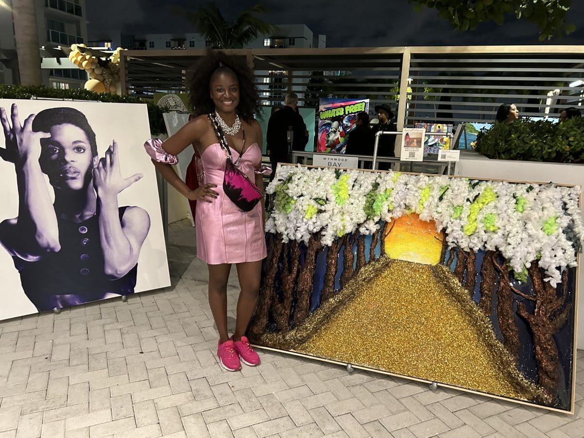 Artist Kudzai B. Mutasa standing near her art during the Art of Love event in Miami Beach on December 8, 2023. 