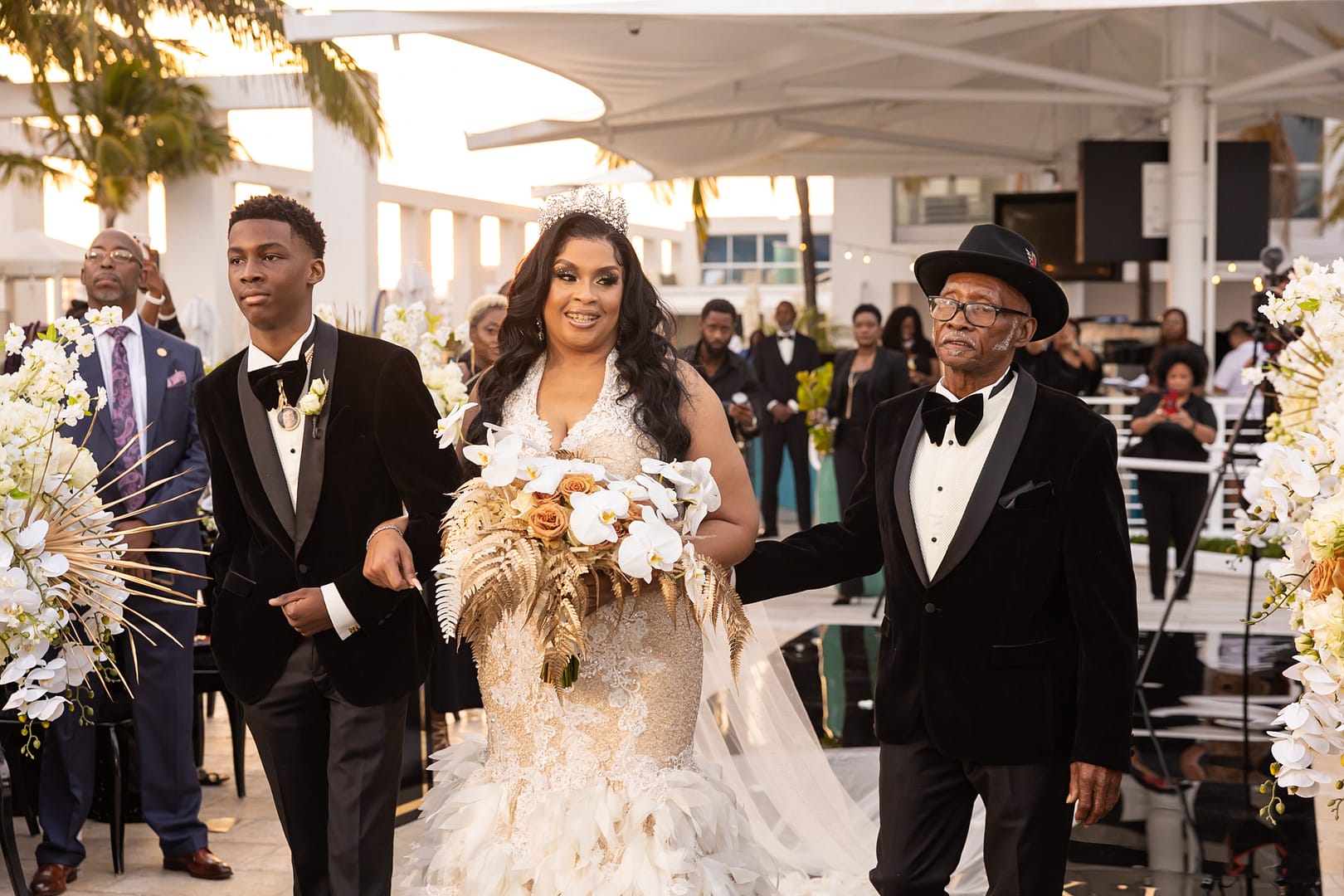 Bride Walking Down the Aisle in Glam Wedding Ceremony with Father of the Bride and Grooms Son