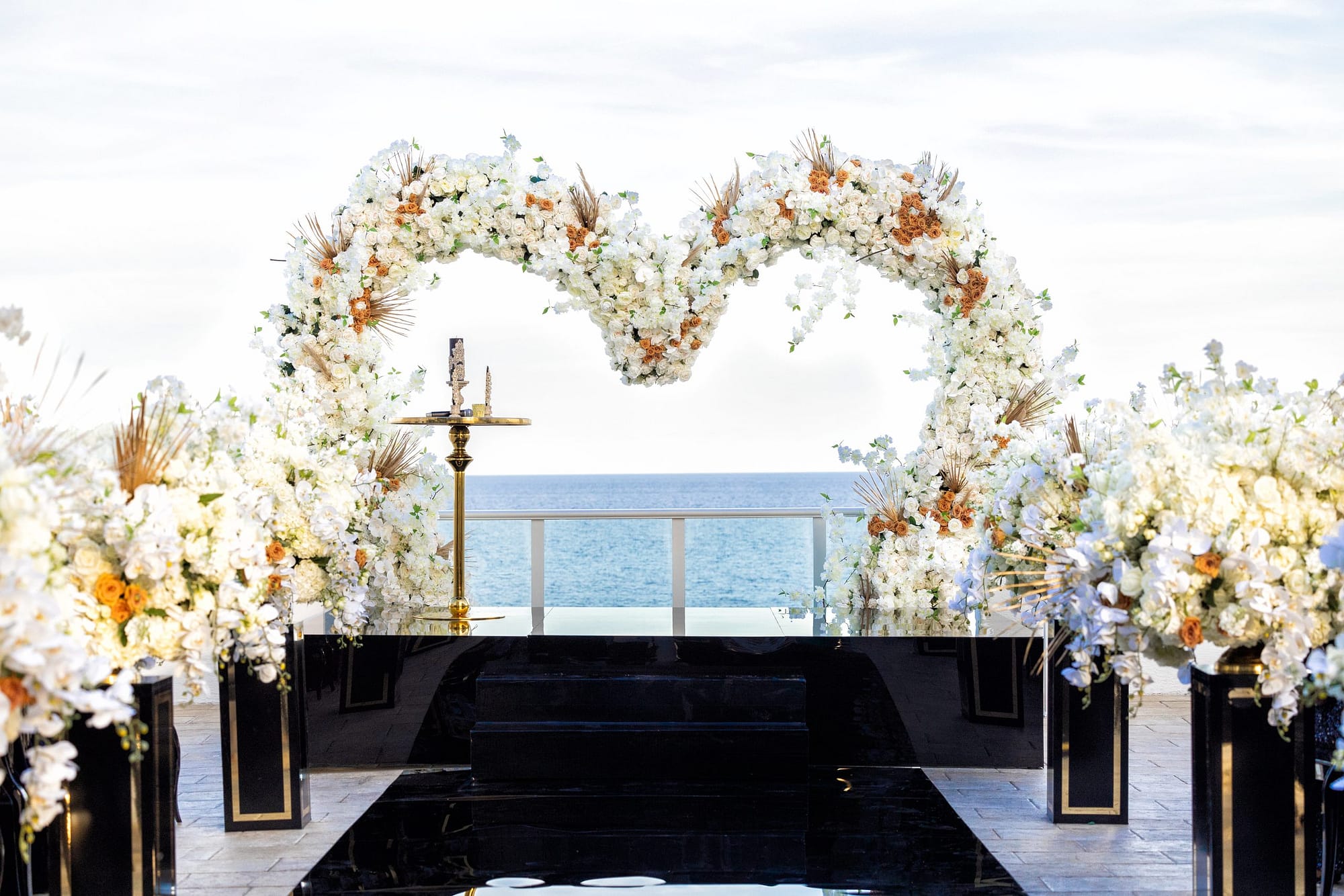 Black Wedding Ceremony Decor with White and Orange Floral Arrangements | Heart Shaped Floral Arch 