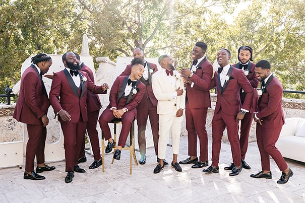 Groom in White Tux and Burgundy Tie with Groomsmen in Burgundy Tuxedos and Black Bow Ties | Wedding Photographer Stanlo Photography
