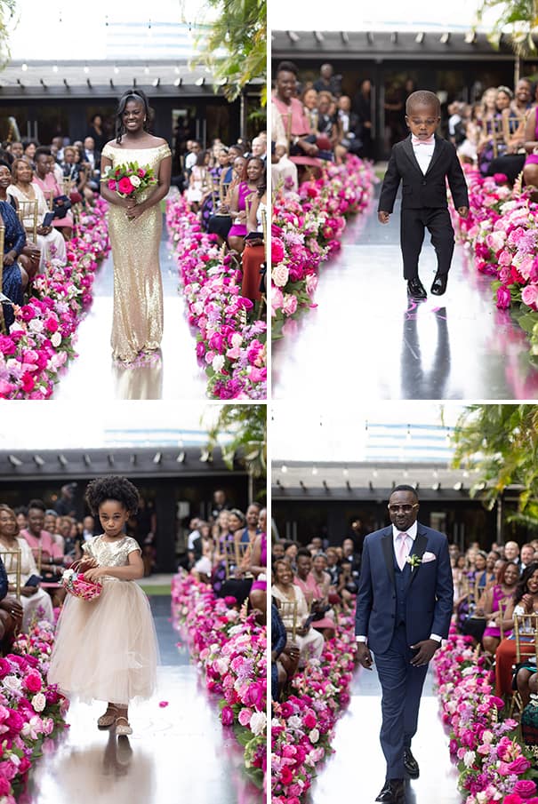 Bridesmaid Walking Down the Aisle in Gold Sequin Floor Length Dress Holding Greenery and Pink Floral Bouquet | Ring Bearer in all Black and Pink Bow Tie Walking Down the Aisle Wedding Portrait | Flower Girl in Gold Sequin Tulle Dress Walking Down the Aisle Wedding Portrait | Groomsmen Walking Down the Aisle in Navy Suit with Pink Tie and Pocket Square