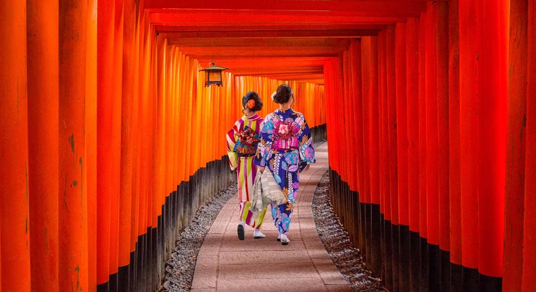 Women in traditional japanese kimonos walking at Fushimi Inari Shrine in Kyoto, Japan
